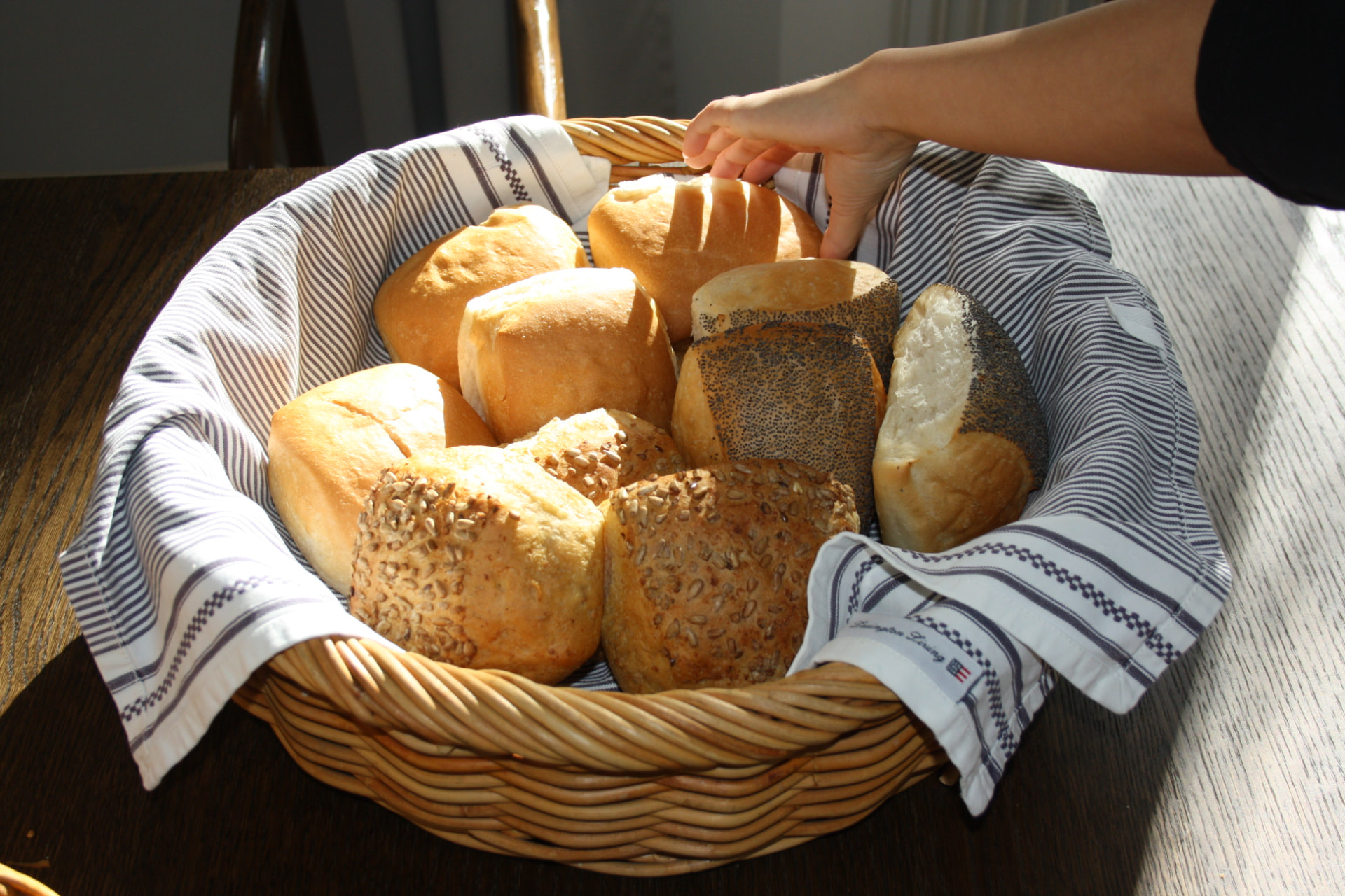 Korg med nybakade frallor som plockas fram till frukost